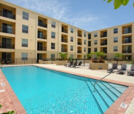 Resort-style swimming pool with lounge chairs at The Ella at ENCORE!