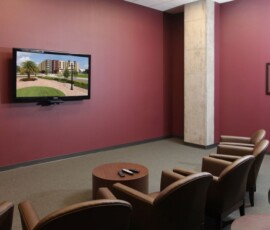 Resident movie theater room with leather chairs and wall-mounted TV at The Ella