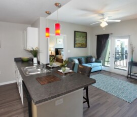 Open concept kitchen and living room with balcony access at The Trio at ENCORE!