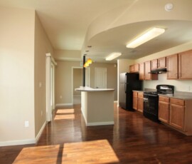 Open-concept living and kitchen area with hardwood floors and center island