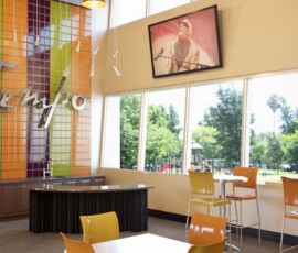 Community lounge and cafe area with colorful tile wall and TV at The Tempo at ENCORE!