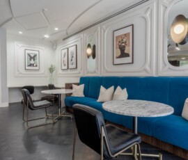 Stylish resident lounge with teal banquette seating and marble tables at Legacy ENCORE!