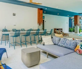 Outdoor covered lounge area with bar seating and pool view at Navara at ENCORE!