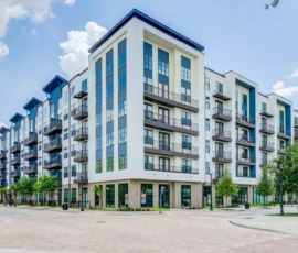 Street-level exterior view of Navara at ENCORE! with blue and white facade and retail
