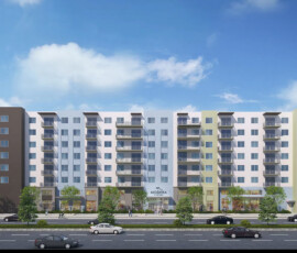 Exterior rendering of modern mid-rise residential building with mixed white and colored facade panels, multiple balconies, ground-level retail spaces, landscaping, street-level parking, blue sky.
